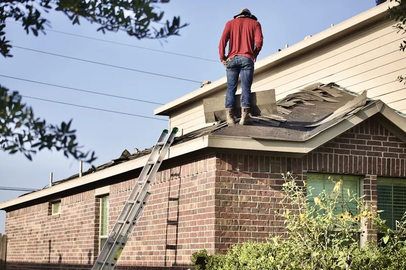 Professional roofer working on a residential roof in Carr